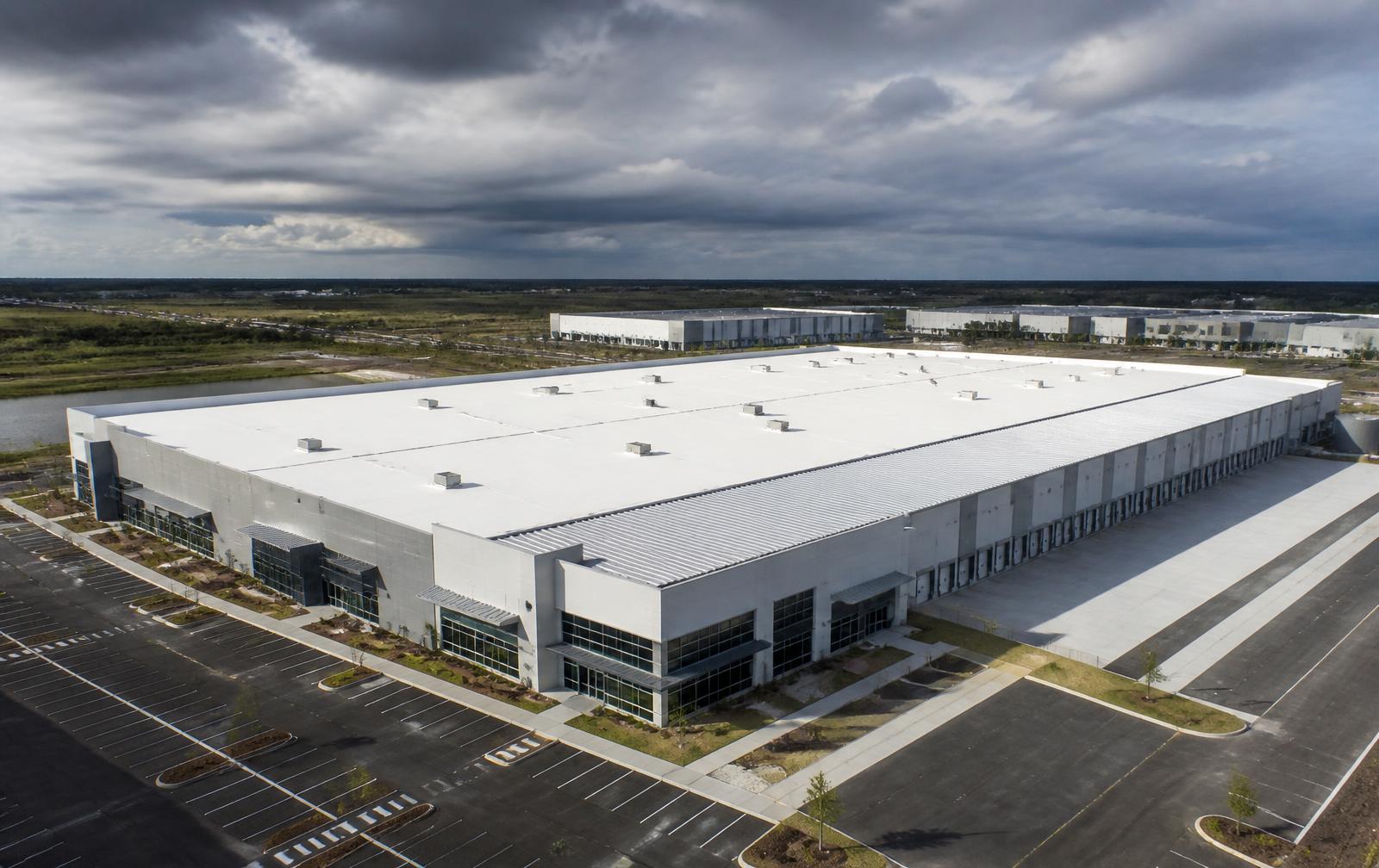 Large industrial warehouse with a white membrane and metal roofing system